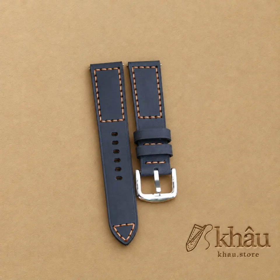 Navy cowhide watch strap with tan hand stitching and a silver-tone buckle — partner workshop photograph