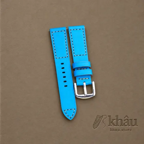 Sky Blue cowhide watch strap with tan hand stitching and a silver-tone buckle — partner workshop photograph