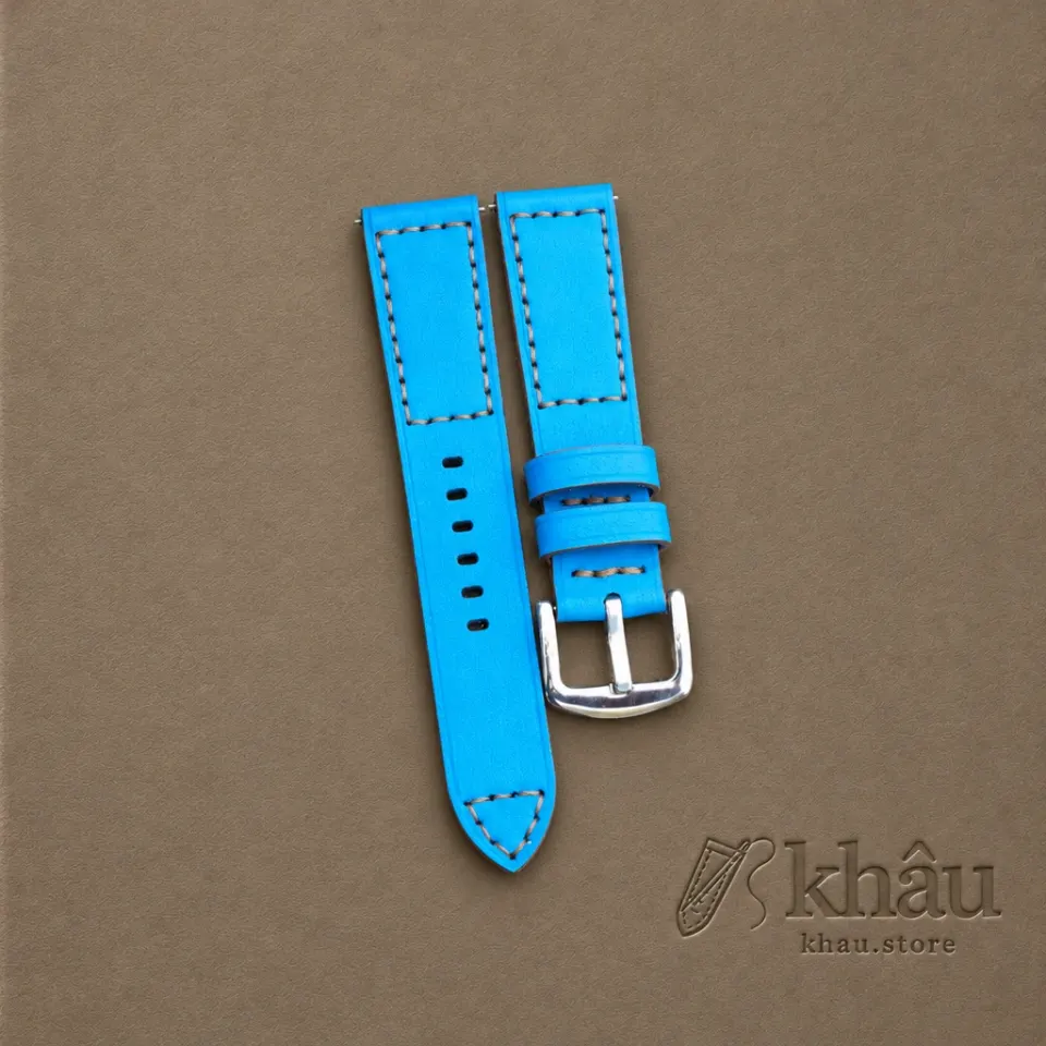 Sky Blue cowhide watch strap with tan hand stitching and a silver-tone buckle — partner workshop photograph