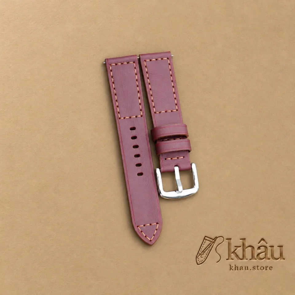 Burgundy cowhide watch strap with tan hand stitching and a silver-tone buckle — partner workshop photograph
