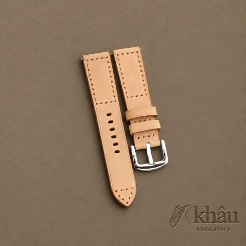 Sand cowhide watch strap with tan hand stitching and a silver-tone buckle — partner workshop photograph