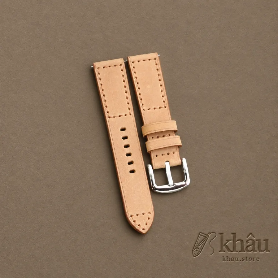 Sand cowhide watch strap with tan hand stitching and a silver-tone buckle — partner workshop photograph