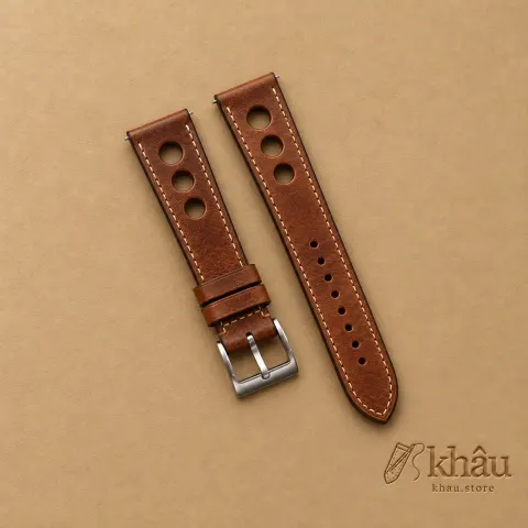 Patina Brown Rally Leather Watch Strap with Khâu debossed branding on a warm tan background