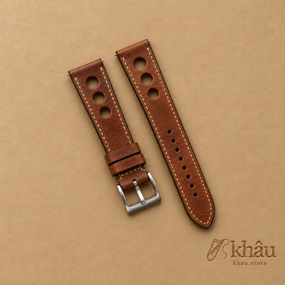 Patina Brown Rally Leather Watch Strap with Khâu debossed branding on a warm tan background